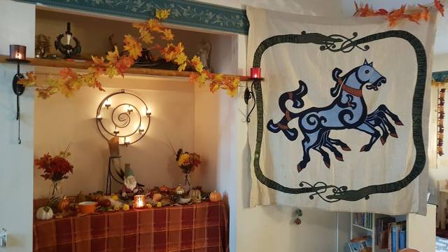 On left, an altar prepared to honour the elves/landwights during a May Day faining. On right, the Freehold banner.
